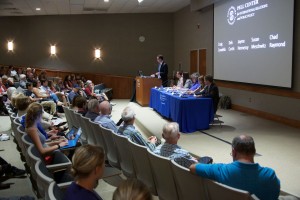 Pell Center Executive Director Jim Ludes moderates the lecture about Pope Francis' encyclical letter as panelists Craig Condella, Deb Curtis, Jayme Hennessy, Susan Meschwitz and Chad Raymond look out upon a crowd of Salve students and Newport community members