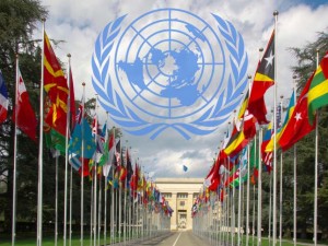 Photo of the national flags gallery at the entrance to UN with the UN logo superimposed above it