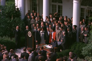 The 1965 Rose Garden signing ceremony with Senator Claiborne Pell immediately behind President Johnson.