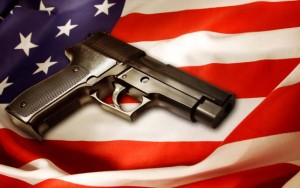 Photograph of a handgun resting on top of an American flag.