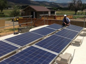 Photograph of a worker installing solar panels.