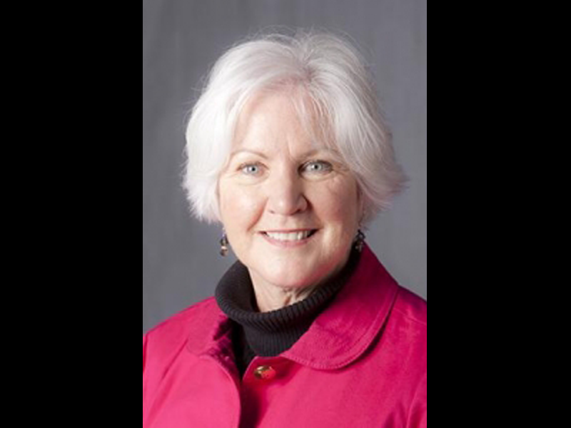 Head shot of Dr. Martha McCann Rose wearing a pink jacket and smiling at the camera.