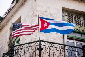 The American and Cuban flags fly side by side on a balcony in Havana, Cuba.