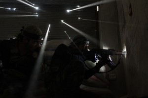 Javier Manzano's Pulitzer Prize-winning photograph of Syrian rebel soldiers guarding their position as light pours through bullet holes in the wall behind them.